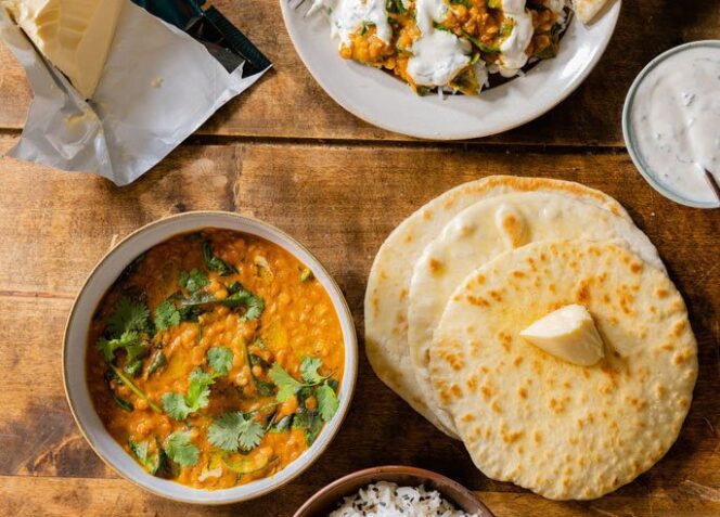 Intialainen dal, naanleipää, raita-kastiketta ja riisiä